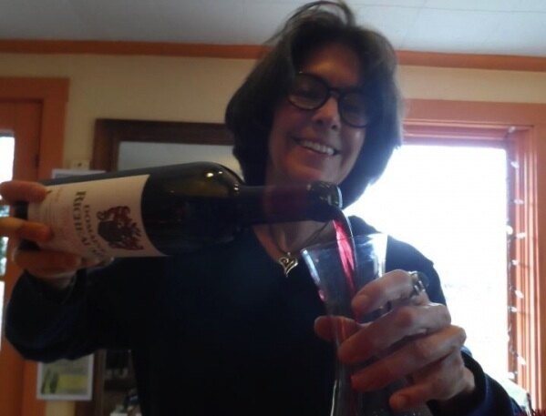 Kay Pfaltz pouring wine at Basic Necessities
